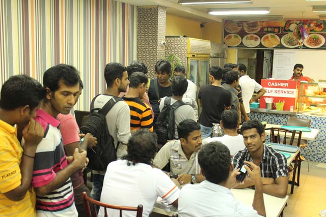 Men queuing to collect their standard meal at TWC2's free meals programme